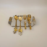 Home Sajawat gold and silver leaf motif serving utensil set with tray. Includes 2 spoons, 1 fork, 1 tong.